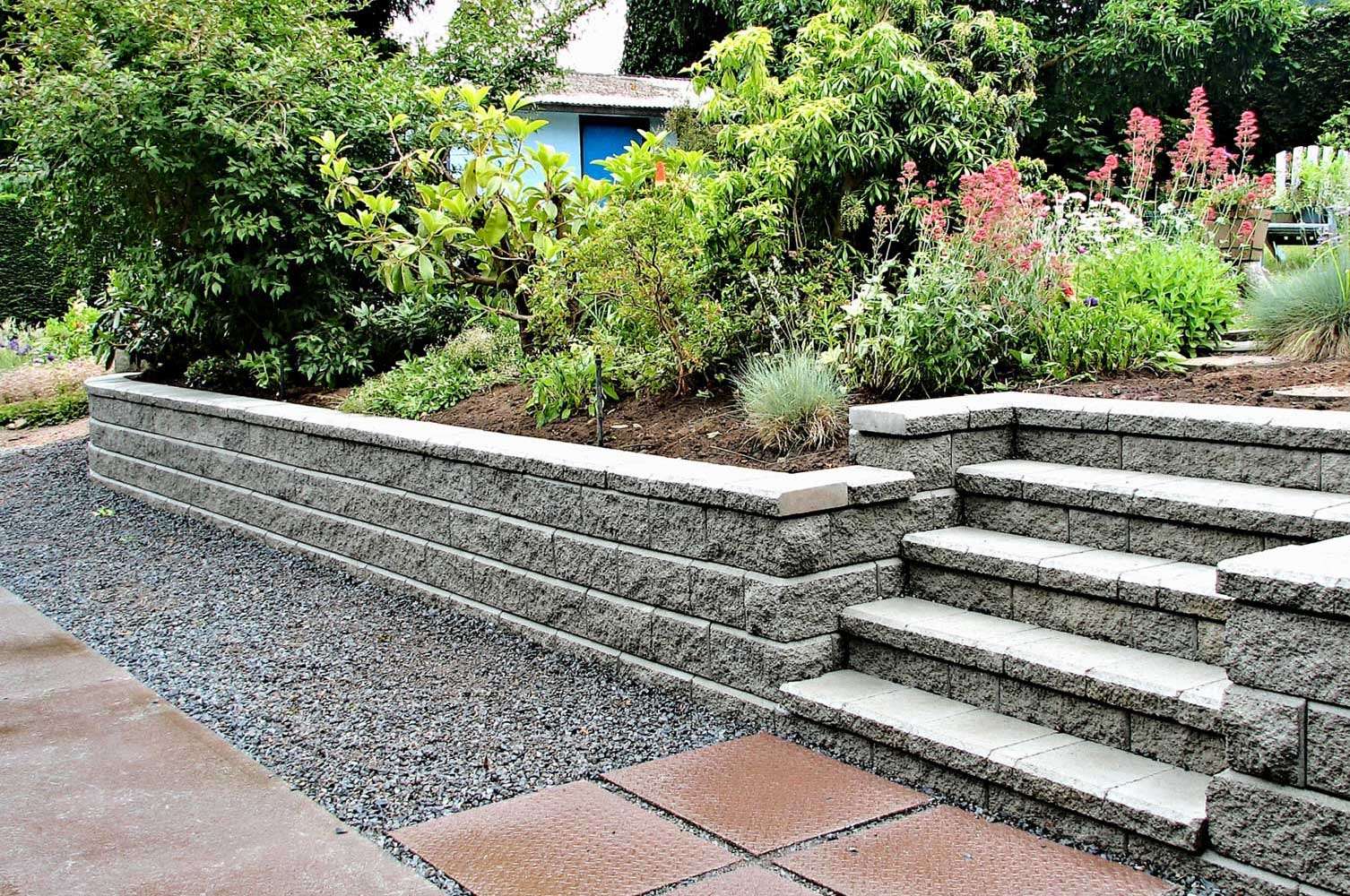 Tiered masonry garden walls with integrated steps and capped block courses