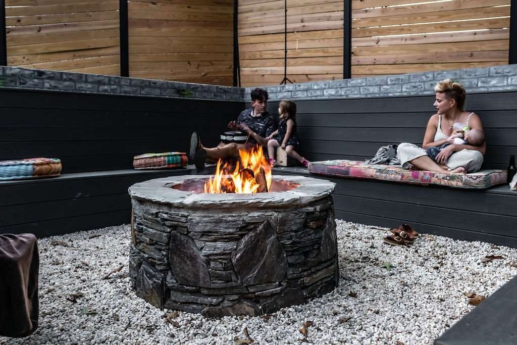 Laughter Family Hardscapes Near Me Asheville NC (4) Cozy outdoor seating area featuring a stone fire pit surrounded by family, showcasing a stylish hardscaping design by Laughter Family Hardscapes in Asheville, NC.