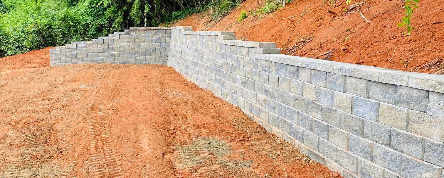 Retaining wall construction underway beside an excavated slope